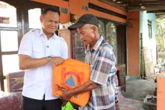 Bupati Purbalingga Fahmi Muhammad Hanif menyalurkan bantuan kepada Yatim Adi Winoto (59), warga Desa Blater, Kecamatan Kalimanah, Kabupaten Purbalingga, yang mengalami musibah kebakaran, Kamis (27/8).(Foto: Prokompim Pemkab Purbalingga)