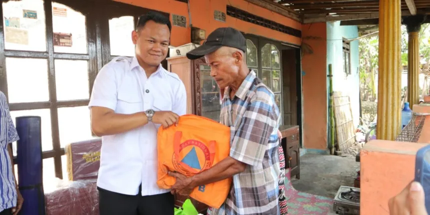 Bupati Purbalingga Fahmi Muhammad Hanif menyalurkan bantuan kepada Yatim Adi Winoto (59), warga Desa Blater, Kecamatan Kalimanah, Kabupaten Purbalingga, yang mengalami musibah kebakaran, Kamis (27/8).(Foto: Prokompim Pemkab Purbalingga)