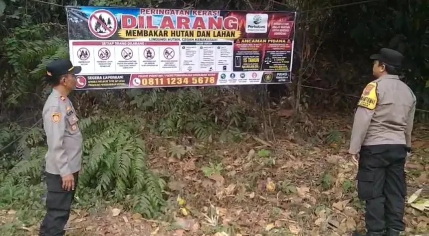 Petugas Polsek Lumbir memasang imbauan berupa spanduk bertuliskan "DILARANG MEMBAKAR HUTAN DAN LAHAN" di kawasan hutan milik Perhutani, Sabtu (12/9/2026).(Foto: Polresta Banyumas)